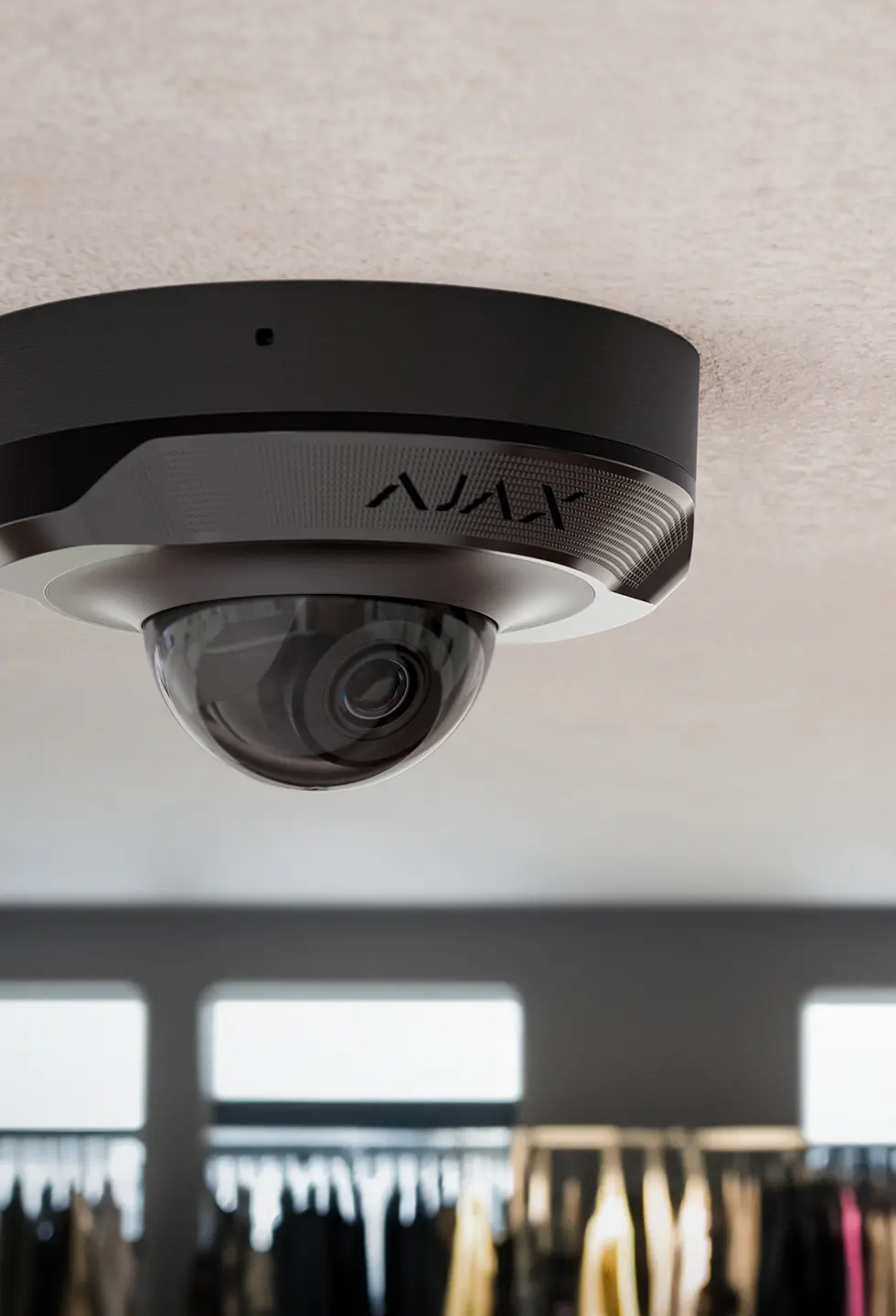 An Ajax dome camera mounted on a ceiling, overlooking the room below